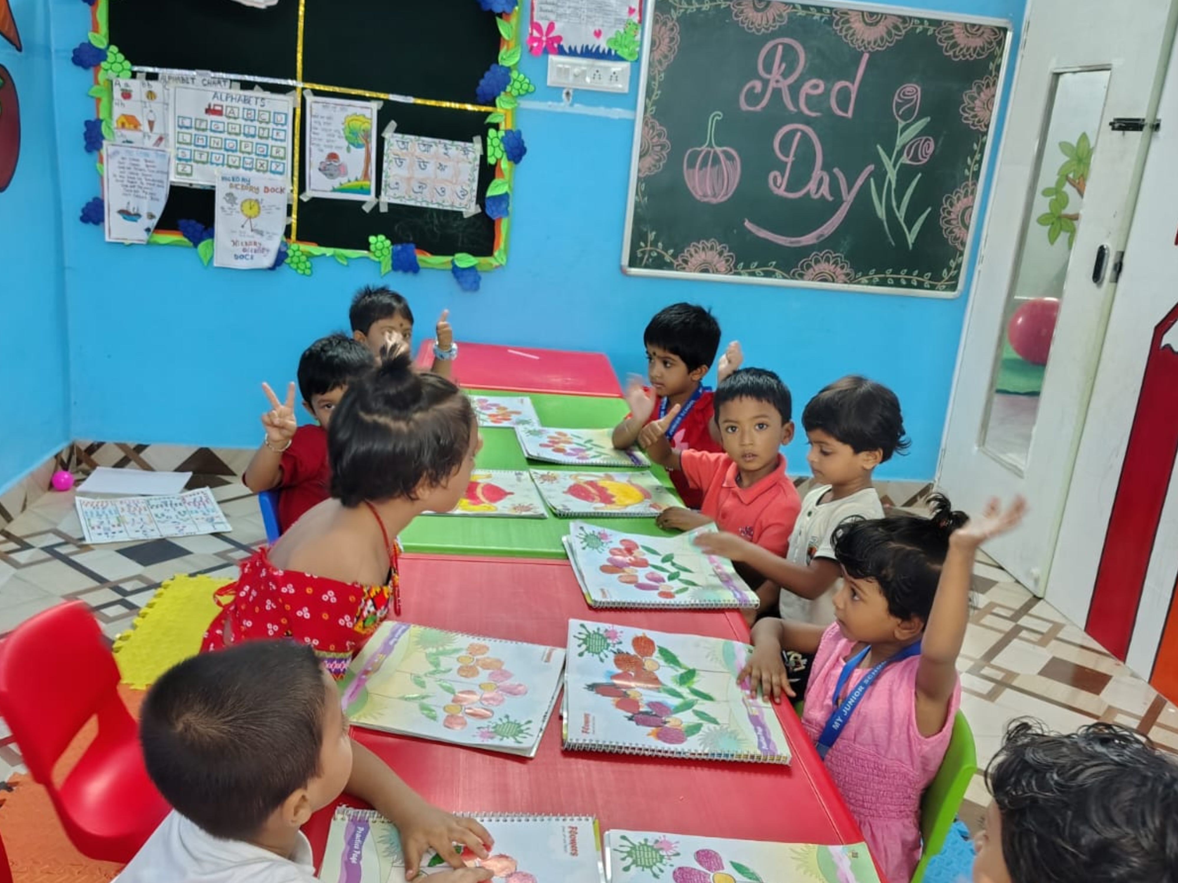 Teacher guiding children during a classroom craft activity